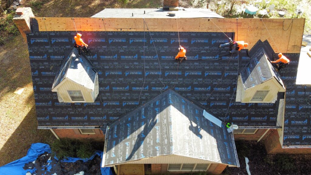 Roofing contractors working on a residential project in Charlotte, NC, showcasing tools and materials on-site.